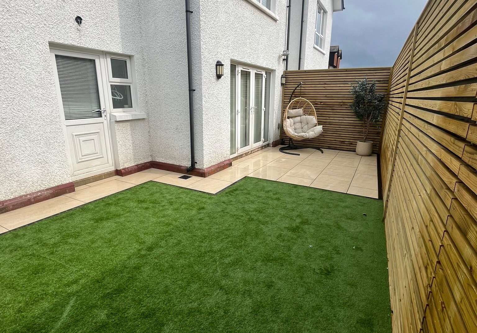 Patio area with swing chair and artificial grass