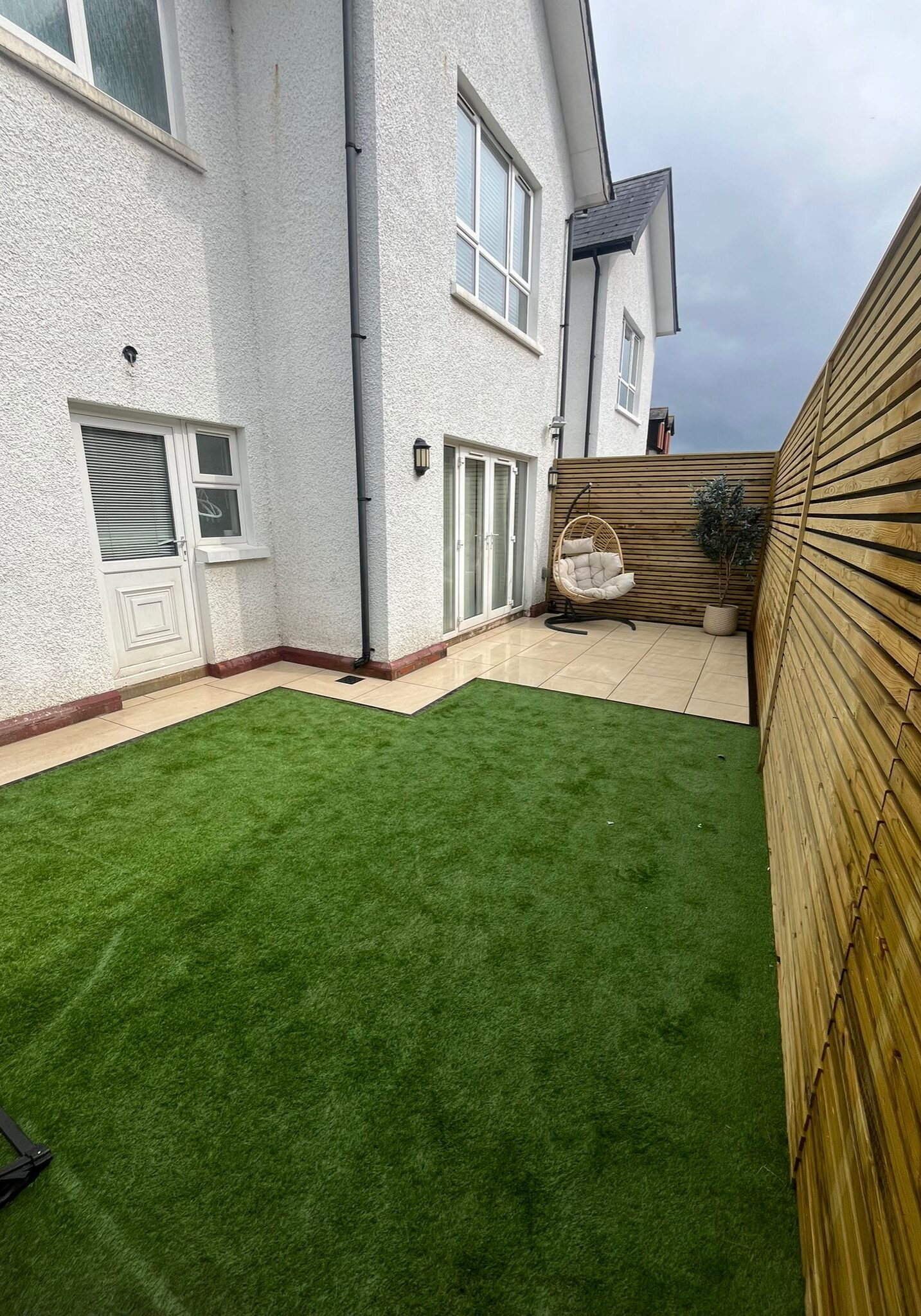 Patio area with swing chair and artificial grass